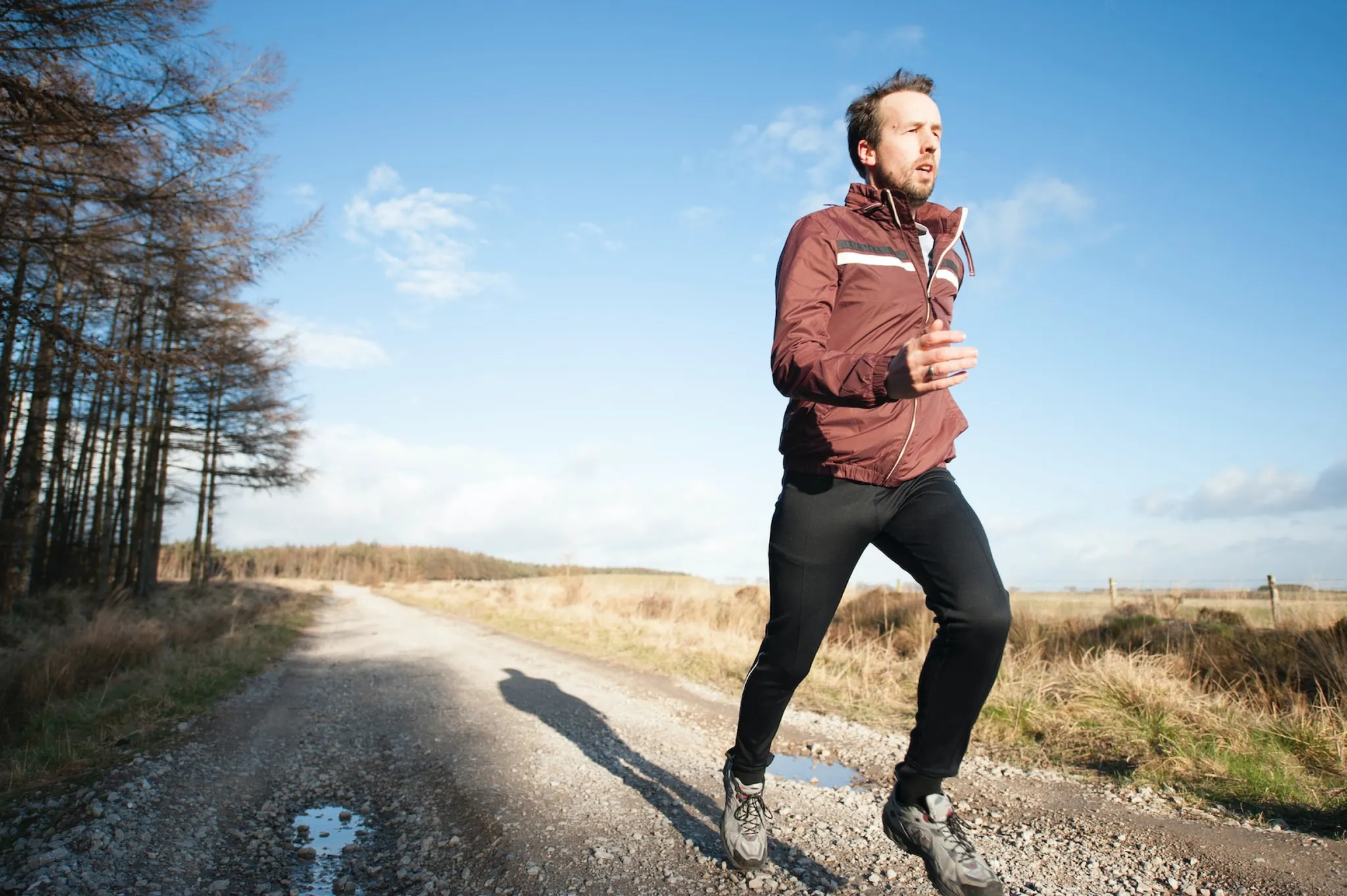 A man running along a gravel path in the morning