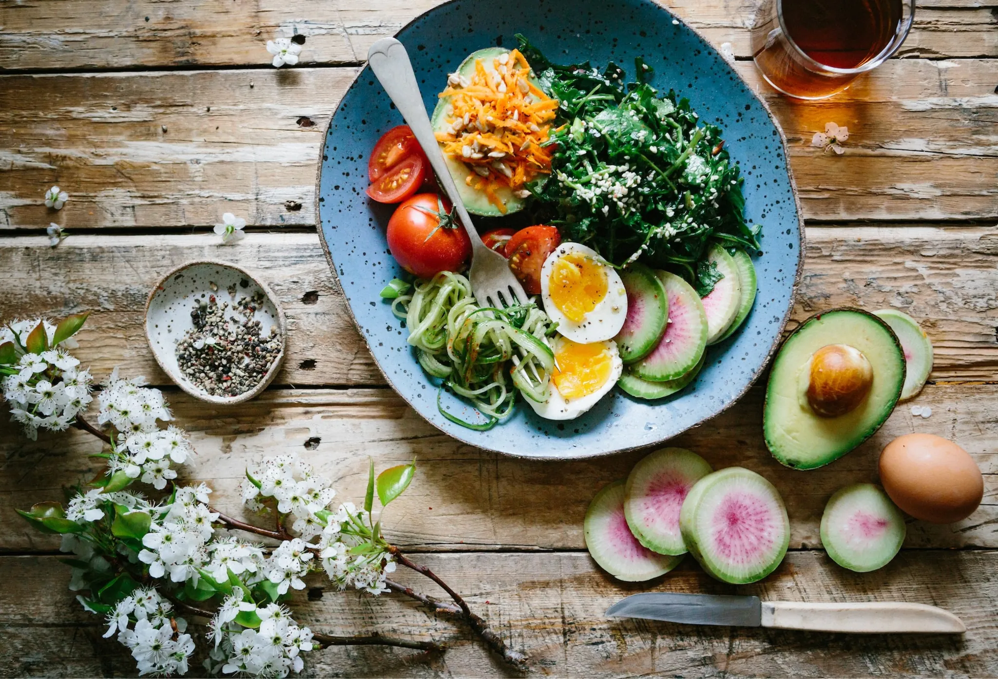 A plate of fresh vegetables, eggs and avocado
