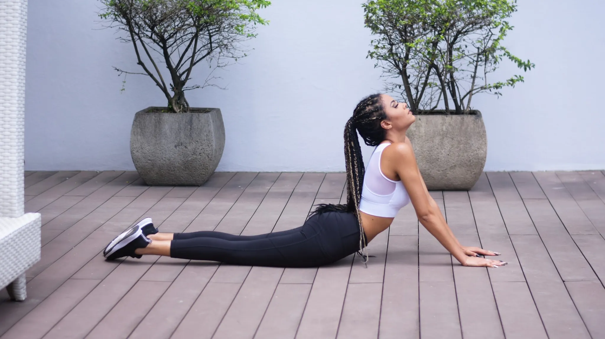 A woman stretching into a backbend on a wooden deck